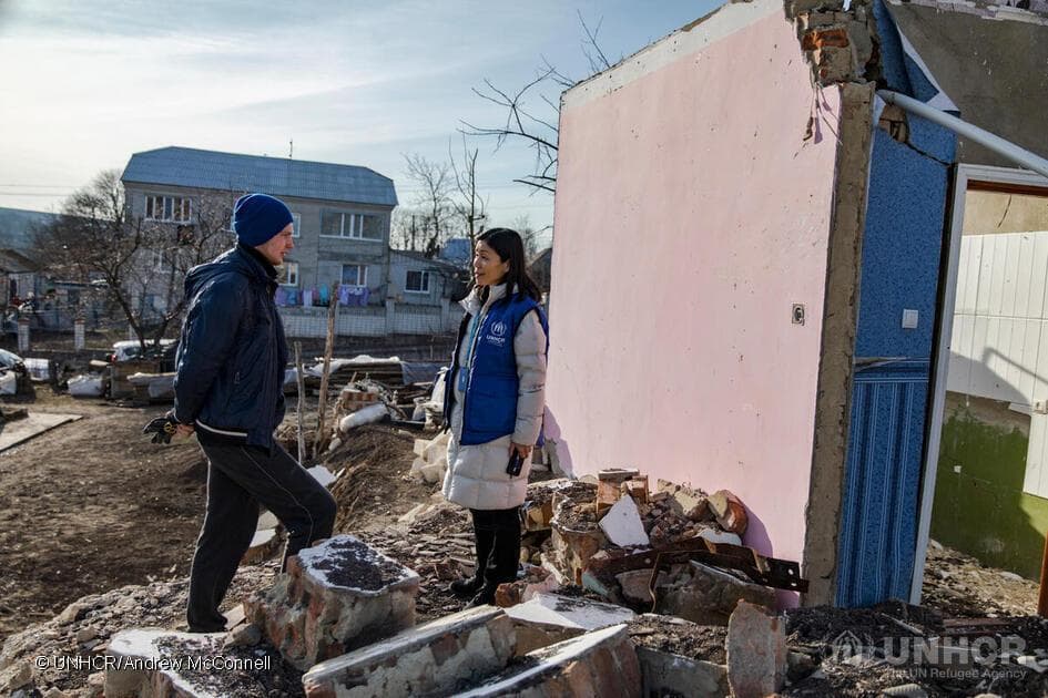 UNHCR Protection Officer Akiko Tsujisaw speaks with Vitali, 22, as she surveys the destruction at his mother's family’s home in a village near Tomashpil, Vinnytsia Oblast, Ukraine, following a missile attack in October 2022. 

Vitali was at home that morning, and only remembers the sound of an enormous explosion and a flash of bright light. The window blinds and glass came crashing in on top of him.  

Rushing outside, he was met by neighbours who had equally been impacted by the blast. His grandmother’s house, across the street from that of his parents’ was destroyed. “The sight was shocking, we couldn’t really understand what had happened,” he says. 

His grandmother had passed away some years earlier, and his parents had planned to move into her house, leaving Vitali and his brother to stay in the family home. His mother Helena had just left his grandmother’s house some five minutes earlier, narrowly missing the attack. ; In a village on the outskirts of Tomashpil, Vinnytsia Oblast, Ukraine, the local community is pulling together to recover after missile attacks. An attack in late October 2022, left several houses badly damaged, with one house destroyed. UNHCR was able to support some households to replace doors and windows, which ensured they were able to keep the cold out during the winter months and stay in their homes. The village has also welcomed some 100 internally displaced people who have found safety in the neighbourhood. 

In 2023, UNHCR Ukraine plans to provide 720,000 people with shelter support, including long-term, transitional and emergency shelter.